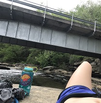 Girl laying on rock by bridge